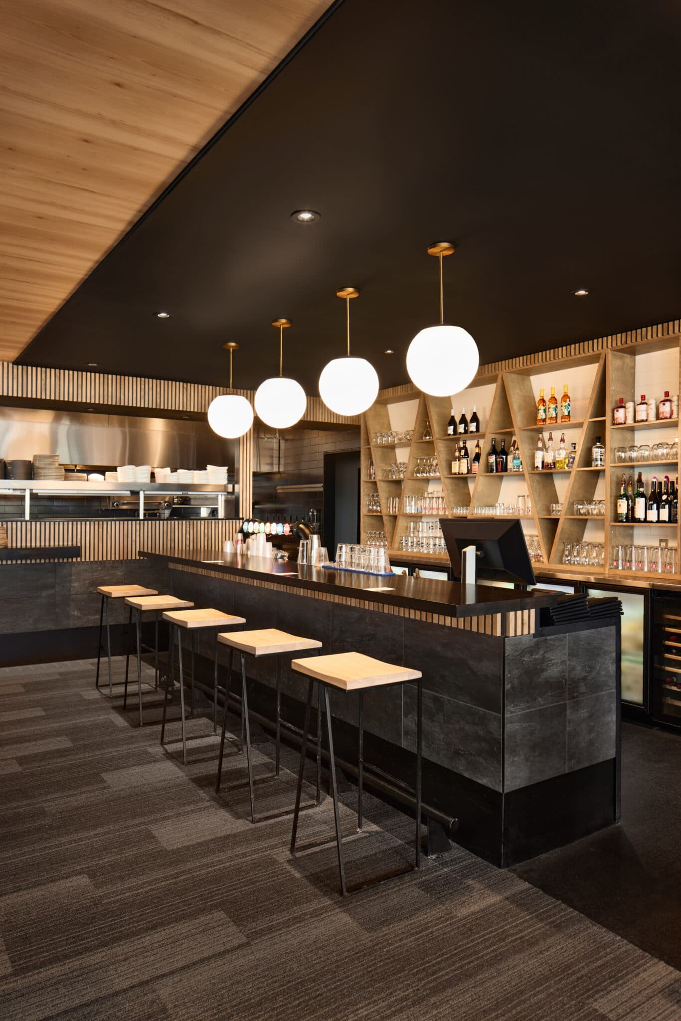 Projet de design corporatif - Coin comptoir bar du Restaurant Bar La Débarque Boutique de ski à Bromont, montage d'expériences par VAD Designers d'intérieur commercial.